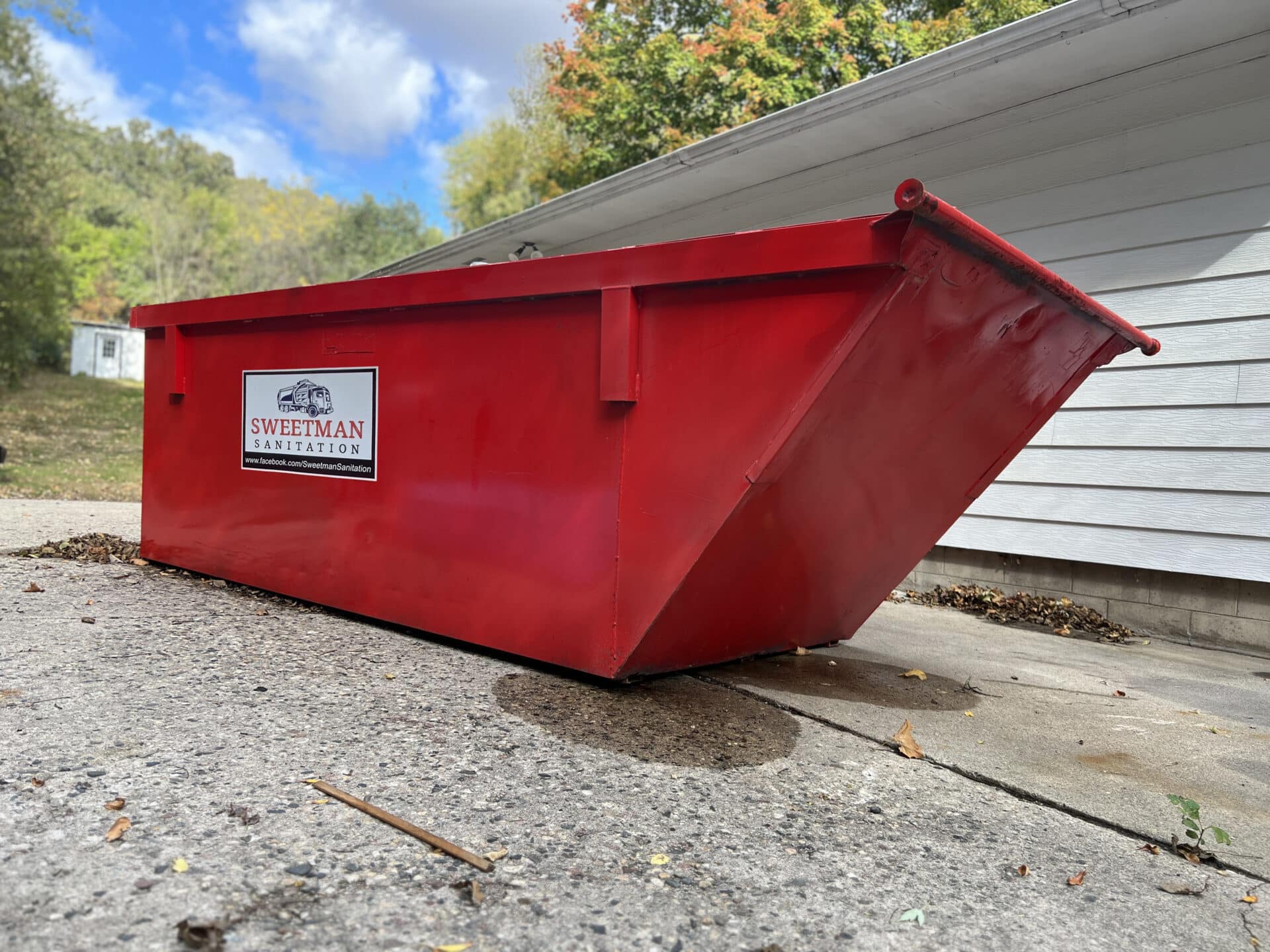 Large Red Dumpster on Cement Driveway