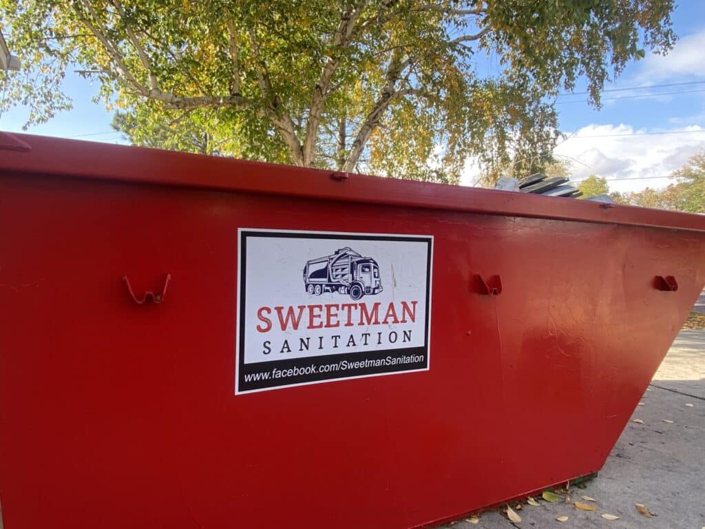 Red Dumpster with Sweetman Sanitation Logo