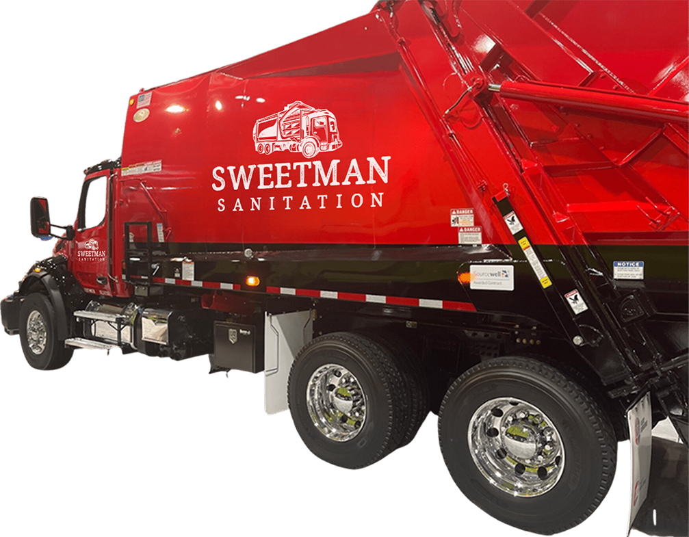 A red garbage truck is parked in front of a white background.