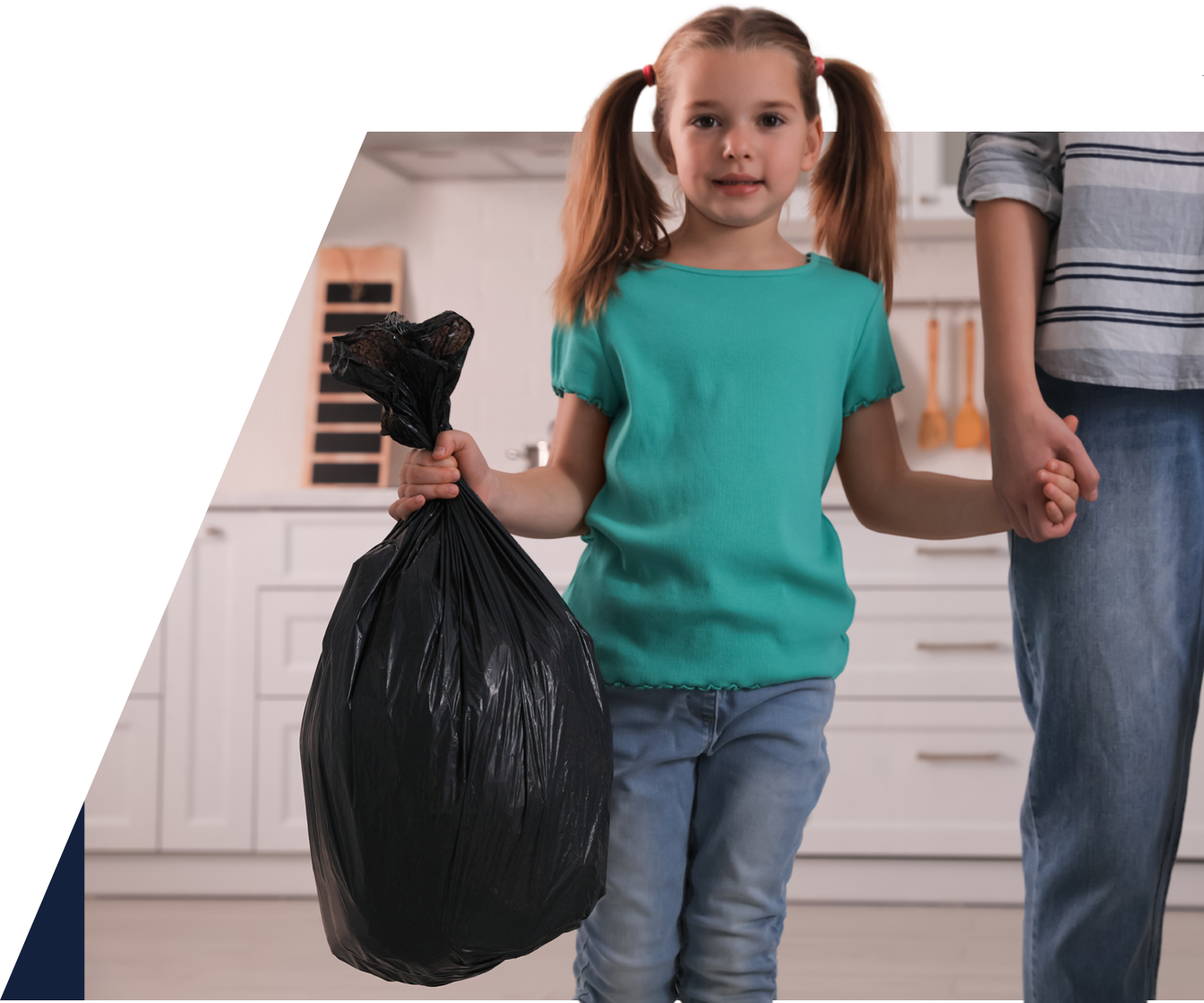 A woman and a little girl holding a black garbage bag.