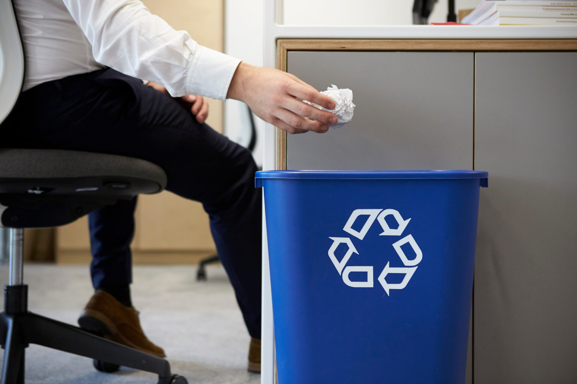 Man Dropping Paper Into Recycling Bin
