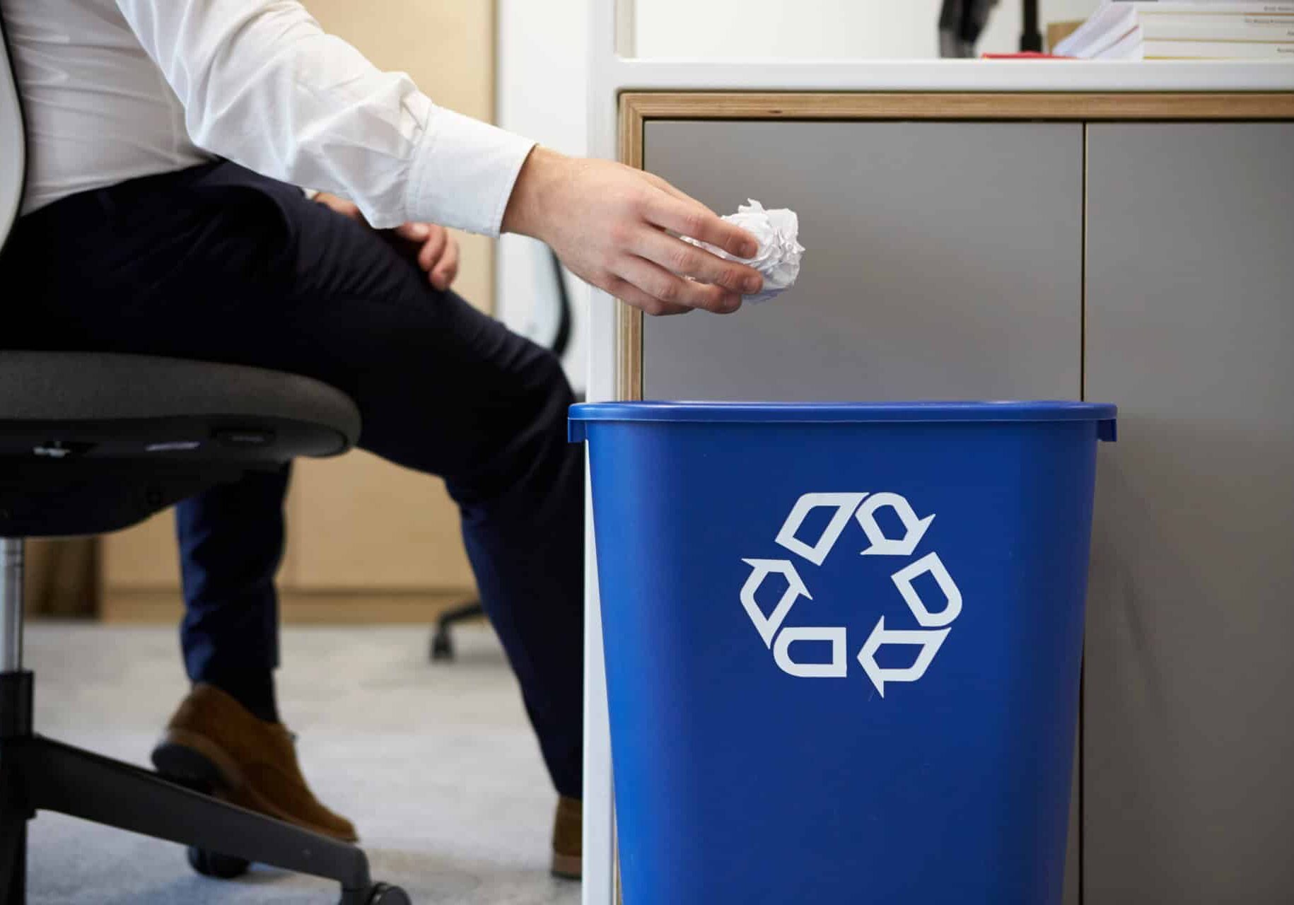 Man Dropping Paper Into Recycling Bin