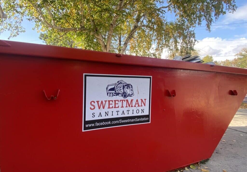 Red Dumpster with Sweetman Sanitation Logo